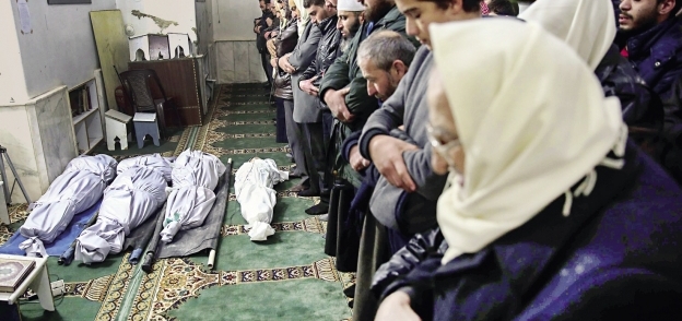 سوريون يؤدون صلاة الجنازة على ضحايا انفجار مخيم الرقبان أمس «أ.ف.ب»