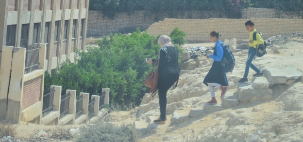 الأطفال يمرون عبر ممر مرتفع للوصول إلى مجمع مدارس «عبدالقادر» بالإسكندرية