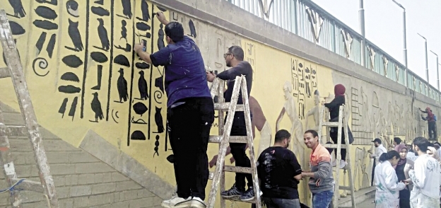 طلاب يرسمون نقوشاً فرعونية على الجدران