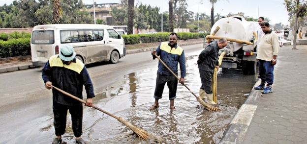 عمال «نظافة الجيزة» أثناء إزالة آثار المياه