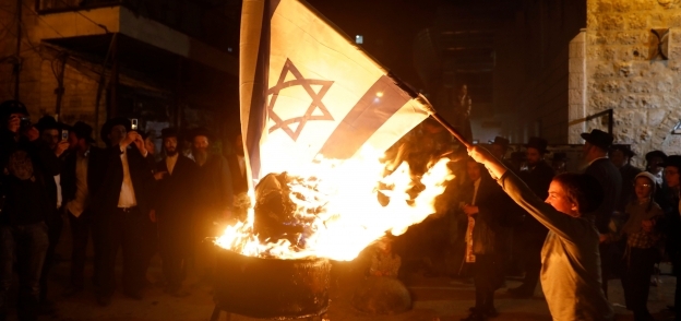 بالصور| يهود يحرقون العلم الإسرائيلي في أحد أحياء القدس