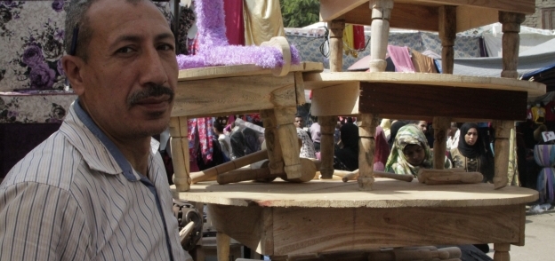 «أسامة» يستعرض الطبلية بأحجام مختلفة فى سوق «إمبابة»