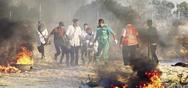 عدد من الفلسطينيين يشعلون الإطارات أثناء احتجاجات فى غزة «أ.ف.ب»