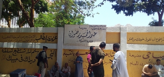 مجموعة من الشباب يقفون أمام مدرسة عبدالحميد رضوان