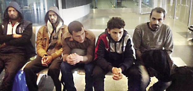 عدد من الشباب العائدين لدى وصولهم مطار القاهرة أمس