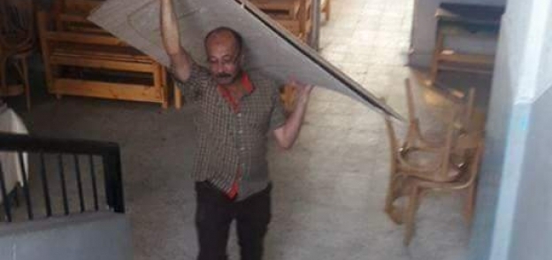 مدير مدرسة الفاروق عمر يحمل ألواح الصيانة على ظهره