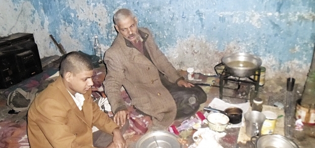 «صفوت» مع ابنه فى المنزل أثناء طهو أرجل الفراخ
