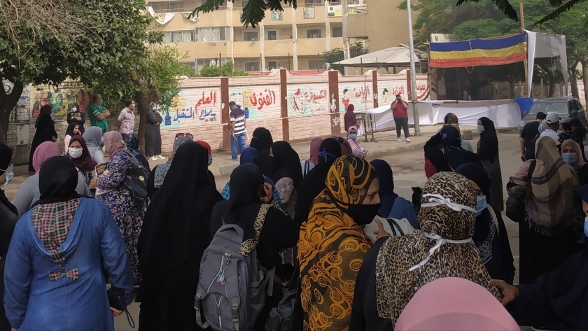أولياء الأمور يقفون خلف الحواجز الحديدية أمام إحدى لجان الثانوية العامة بشارع الهرم
