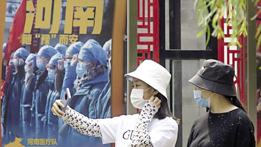 فتاتان تلتقطان الصور بالقرب من لوحات تكرم الأطباء بالصين