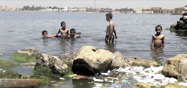 أطفال قرية شكشوك يسبحون فى مياه البحيرة الملوثة