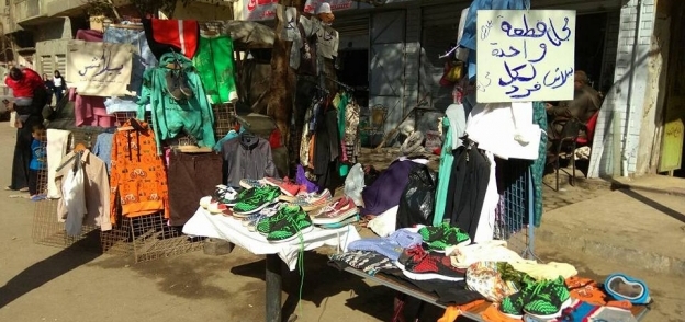 فرش الملابس أمام محل عم محمد