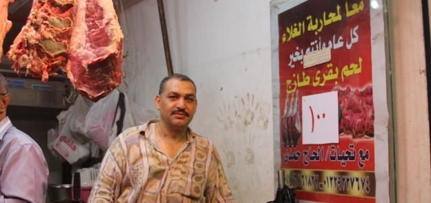 «حمدى» أمام لافتة محاربة ارتفاع الأسعار