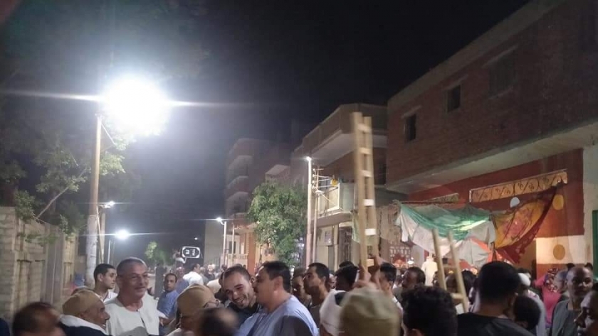أنصار مرشح يرفعون السلالم الخشبية في مسيرة انتخابية ببني سويف