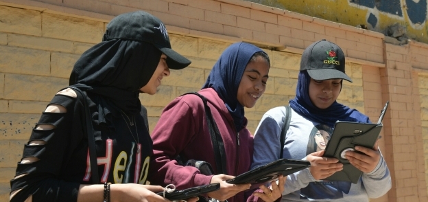طالبات يراجعن الامتحان بعد خروجهن من اللجان