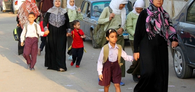 أمهات يصطحبن أطفالهن إلى المدرسة