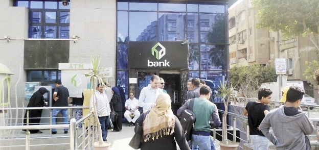 عدد من المواطنين أمام أحد فروع البنك لشراء كراسات الشروط