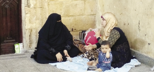 أسرة هربت من الحر إلى ساحة مسجد الحسين