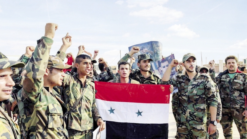 عناصر من الجيش السورى ترفع علم سوريا فى منبج شمالاً "أ.ف.ب"