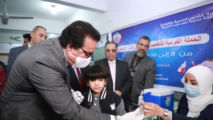 الدكتور خالد عبدالغفار خلال تطعيم أحد الأطفال