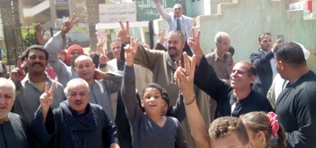 مواطنون يرفعون علم مصر عقب الإدلاء بصوتهم في الانتخابات
