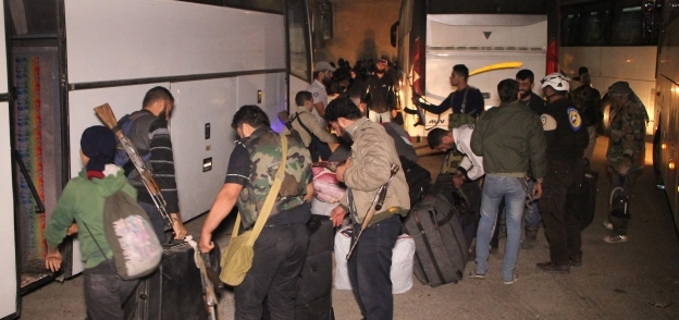 عدد من المقاتلين السوريين وأسرهم لدى وصولهم إلى «إدلب»