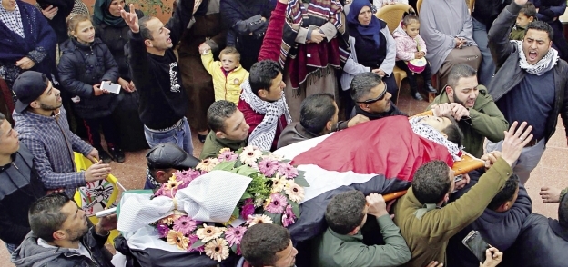 فلسطينيون أثناء تشييع جثمان الشهيد مصعب التميمى «أ.ف.ب»