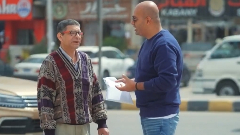 الإعلامي أيمن مصطفى مع موظف الأمن ببرنامج «حياة كريمة»