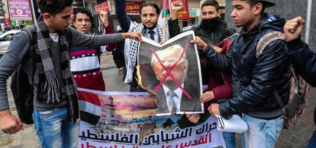 فلسطينيون يشعلون النيران فى صورة الرئيس الأمريكى اعتراضاً على القرار المنتظر «أ.ف.ب»