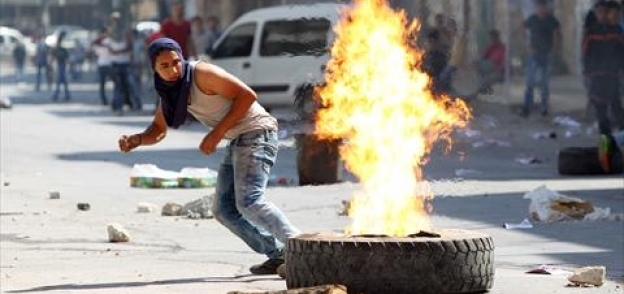 فلسطينى يواجه قوات الاحتلال الإسرائيلى بالحجارة «أ. ف. ب»