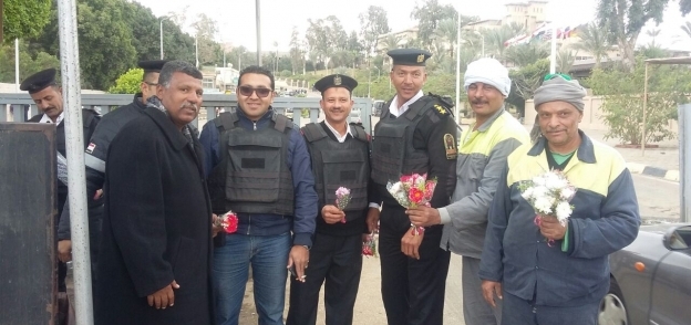 عمال نظافة الجيزة يوزعون باقات الورد على رجال الشرطة