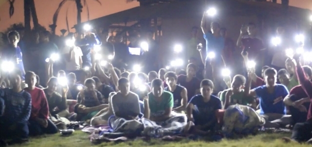 الطلاب أثناء اعتصامهم بكشافات الهواتف المحمولة بعد انقطاع الكهرباء