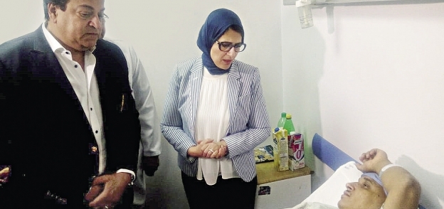 الدكتورة هالة زايد وزيرة الصحة أثناء مرورها على أحد المرضى الذين أجريت لهم عمليات جراحيةبقوائم الانتظار