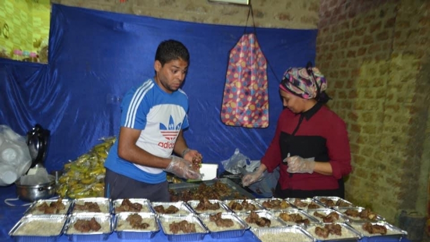المتطوعون أثناء تجهيز الوجبات لتوزيعها على الصائمين اليوم