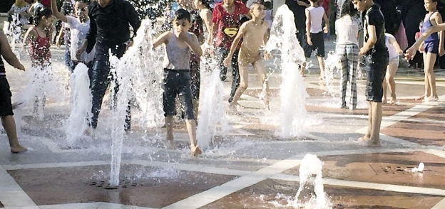 أطفال يلعبون فى مياه النافورة بحديقة «الأزهر بارك»