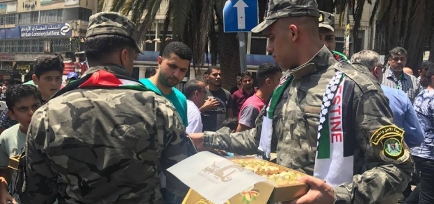 الشرطة الفلسطينية توزع الحلوى ابتهاجا بإزالة الحواجز بالأقصى