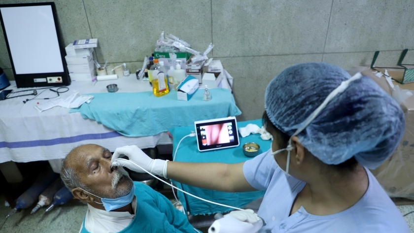 ممرضة هندية تفحص احد المرضى للتاكد من خلوه من الفطر الاسود