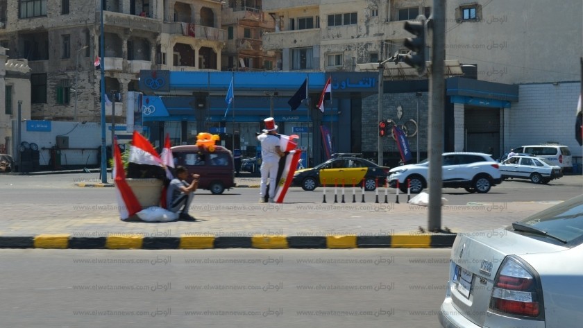 باعة الأعلام ينتشرون حول إشارات الكورنيش فى الإسكندرية