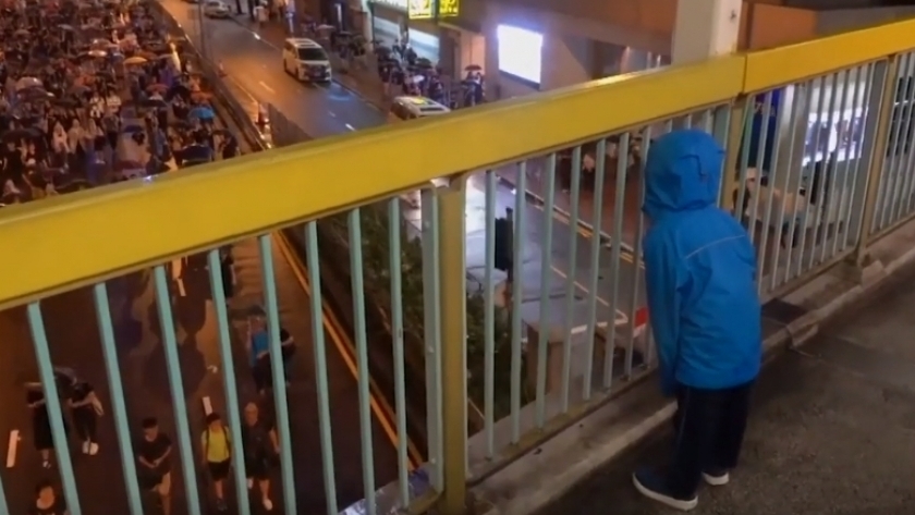 طفل يهتف للمتظاهرين أعلى جسر في هونج كونج