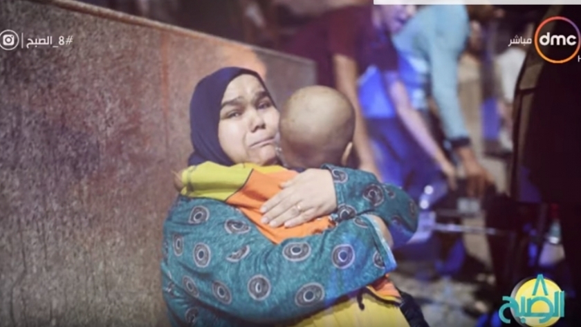 فايزة أثناء احتضانها طفلها بعد انفجار معهد الأورام