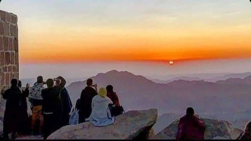 سياح فوق قمة جبل موسى يشاهدون شروق الشمس