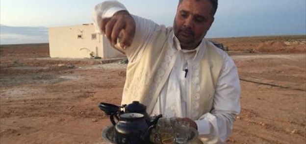 محمد زايد من ابناء قبيلة العشيبات بمطروح يصب الشاى الزردة فى الصحراء
