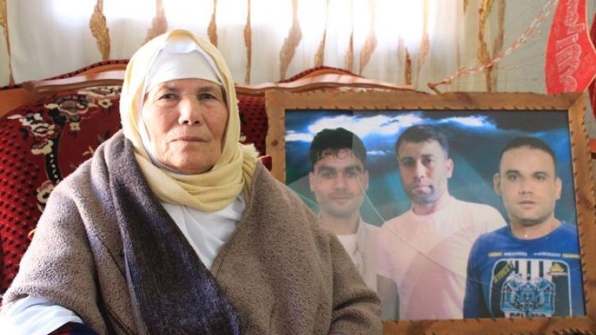 والدة الأسير الفلسطيني محمود عبد الله العارضة أمام صورته