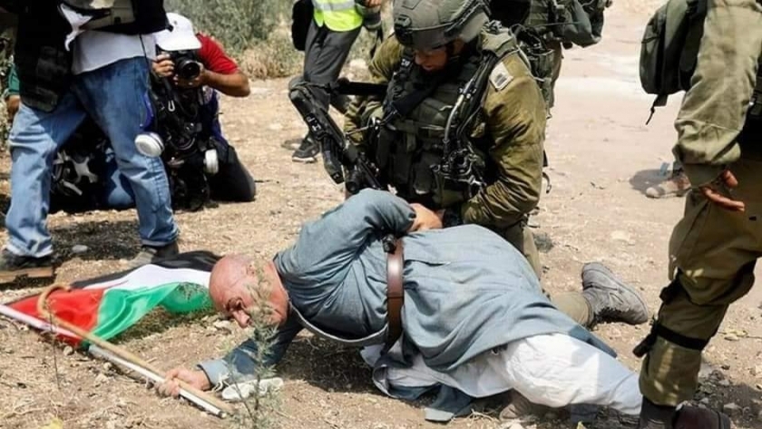 جندي إسرائيلي يعتدي على مسن فلسطيني