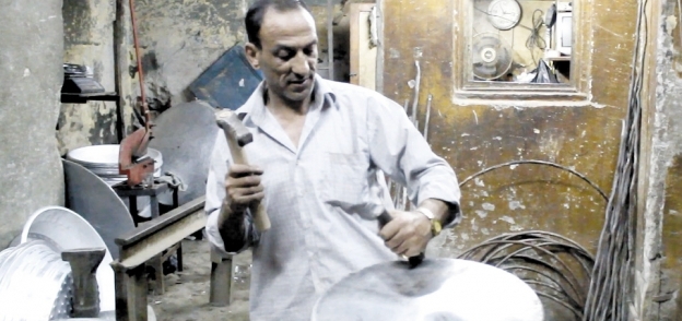 «حسين» صاحب ورشة تصليح قدور الفول