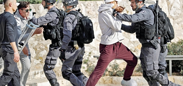 شباب فلسطينيون يتحدون جنود الاحتلال فى محيط المسجد الأقصى أمس «أ. ف. ب»