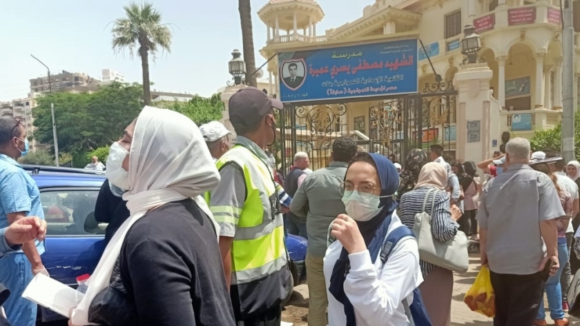 طلاب وأولياء أمور أمام إحدى مدارس مصر الجديدة