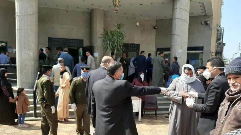 توزيع قفازات على المواطنين أمام البنوك ببني سويف