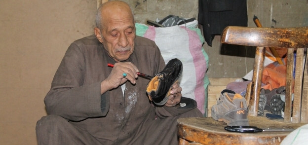 «عم محمد» يلمع الأحذية ليعرضها للبيع