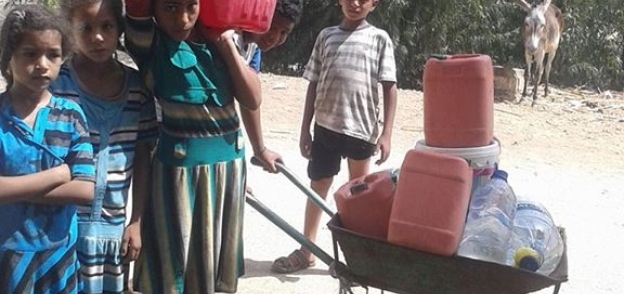 الأطفال ينقلون المياه إلى منازلهم بعد انقطاعها عن قرية دشنا