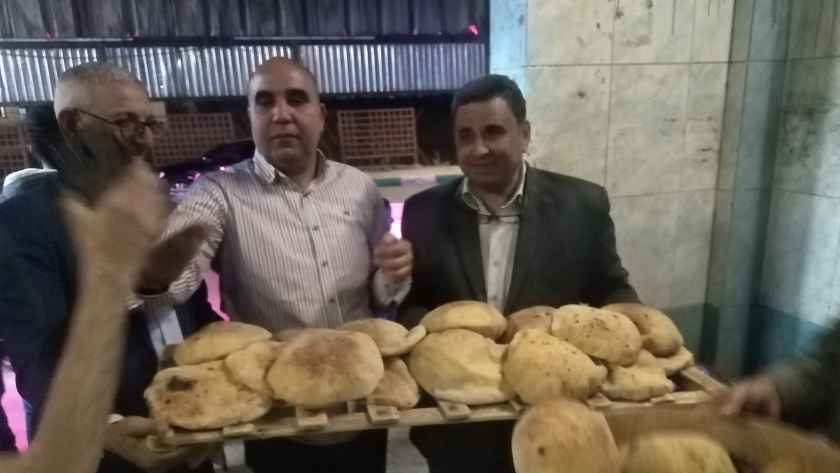 الدكتور عبد المنعم الجندي على يمين الصورة حاملا الخبز المعجون بالبطاطا